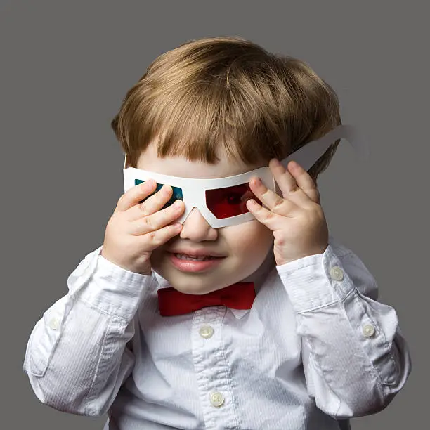 Photo of Excited child with 3-D glasses watching three-D film