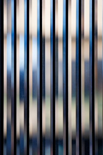 Vertical strips of beveled glass create an abstract background. Glass is in focus but not image beyond.