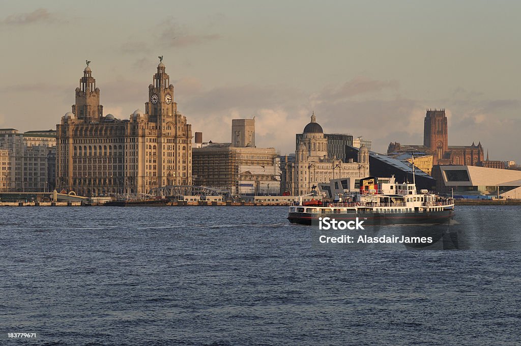 The Mersey Ferry The Ferry across the Mersey and the Liverpool Skyline bathed in the last rays of the setting sun. Liverpool - England Stock Photo