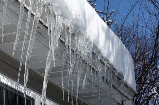 Icicles hang from the roof of a house after a hard winter.