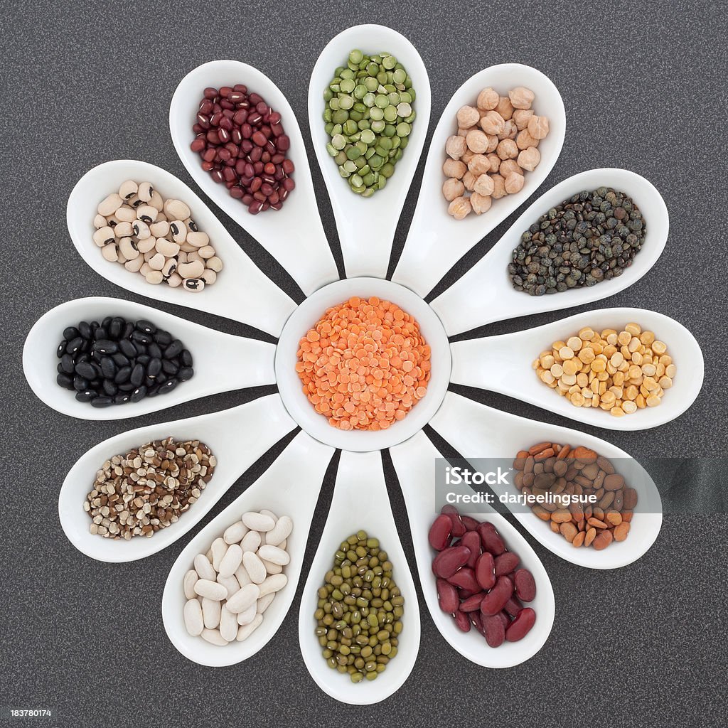 Selection of dried beans, lentils and peas "Porcelain spoons and dish containing colorful dried beans, lentils and peas arranged on a gray counter top. Soft shadows." Dahl Stock Photo