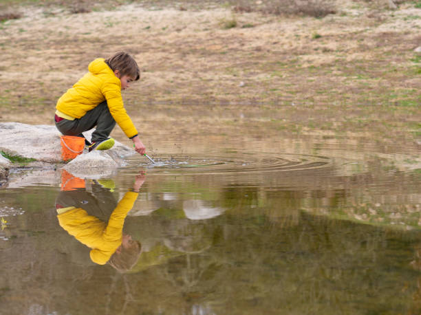 Boy playing in a lake to fish with a net