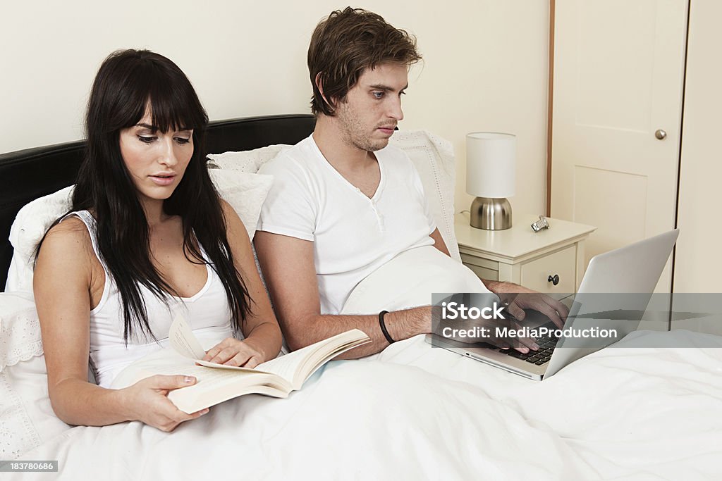 Jovem Casal na cama a ler e surfar na intenet - Royalty-free 20-29 Anos Foto de stock