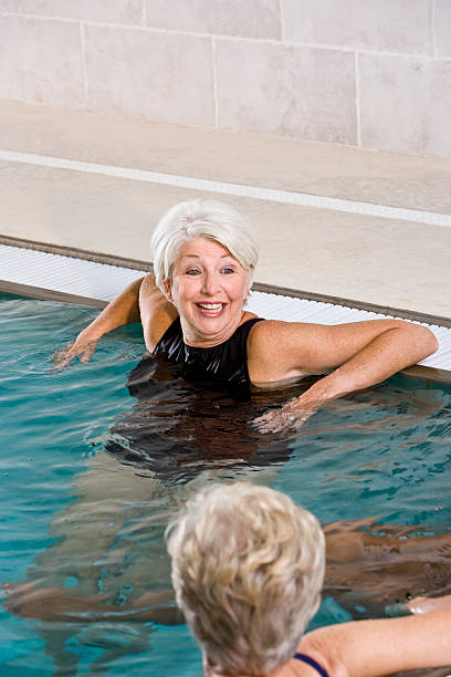 femme âgée avec des amis dans la piscine - sc0450 photos et images de collection