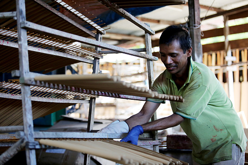 Asian male working in sculpting joss stick factory.