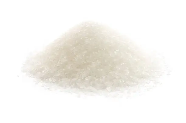 A heap of white processed granulated sugar, isolated on a white background.