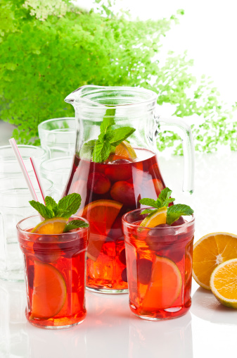 Refreshing Fruit Sangria in Jug with Two Served Glasses on Reflective Surface