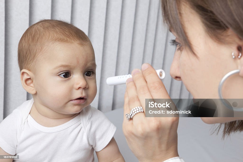 Pediatrician Checking Baby's Eyes A pediatrician checking an 8 month old baby's eyes with a penlight. Baby - Human Age Stock Photo