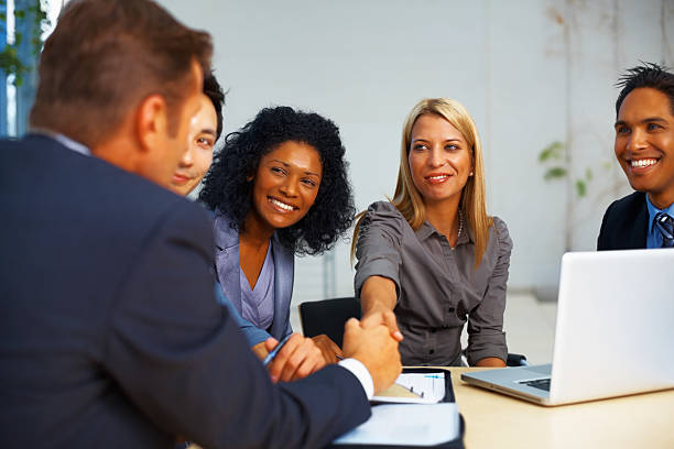 istock Woman congratulating colleague during meeting 183782279