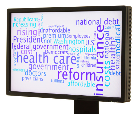 Words relating to health care reform in the US are displayed in a word cloud on an LCD computer monitor.