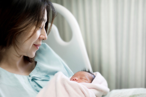 Soft focus of happy mother with newborn baby