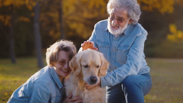 Happy family of two people with dog relaxing in park