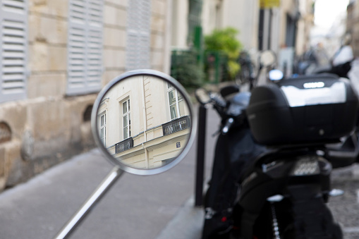 French city apartment buildings in the mirror of a motor scooter
