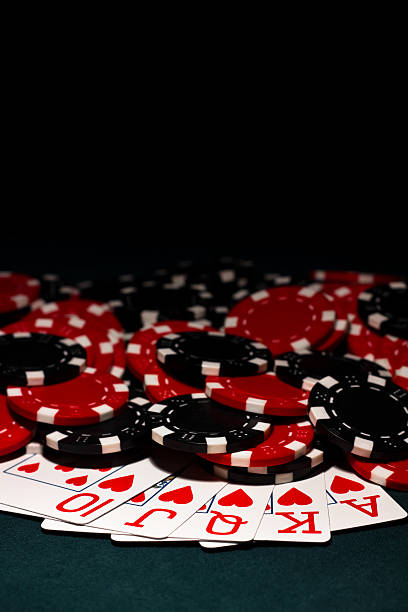 Royal Flush with Black and red Poker Chips Royal Flush of Hearts and a pile of red and black poker chips set against a green felt poker table wsop stock pictures, royalty-free photos & images