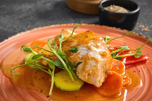 Succulent pan-fried turkey fillet served with crisp vegetables and a tangy sweet chili sauce, beautifully plated on a coral dish.
