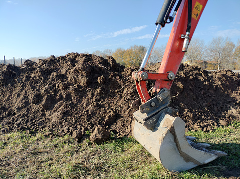 Mechanical Arm of escavator  in foreground with accumulation of escavated earth