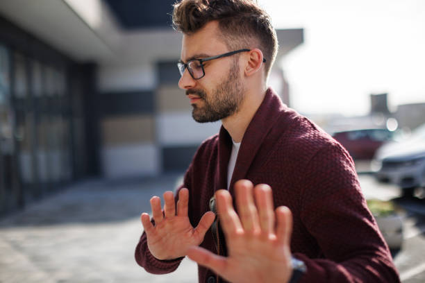 Young man showing stop gesture, saying no, protesting or refusing Young man showing stop gesture, saying no, protesting or refusing refusing stock pictures, royalty-free photos & images