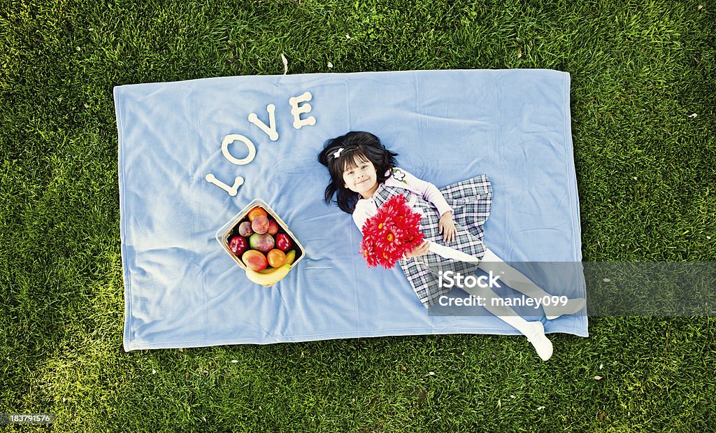 Menina que estabelece na toalha de piquenique com flores e Amor - Royalty-free 12-15 Meses Foto de stock