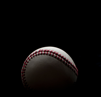 Backlit Baseball shot on a black background fading to black