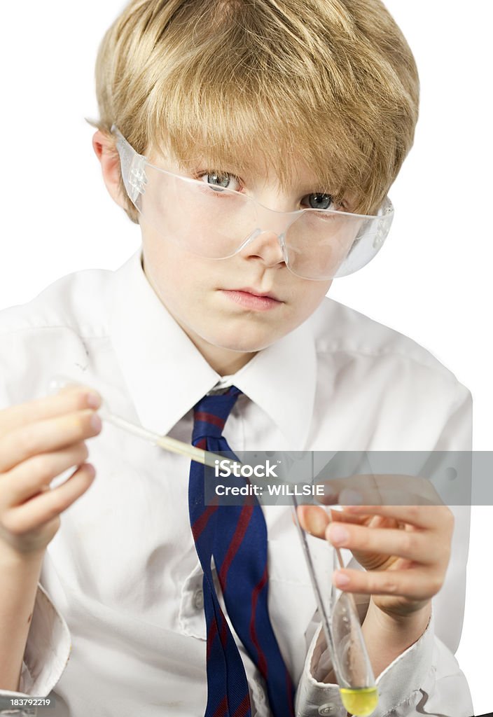 young scientist doing a chemistry experiment An 8 year old boy wearing school shirt and tie holding a test tube and pipette and wearing goggles during a chemistry experiment. White background. sharp focus on eyes. 8-9 Years Stock Photo