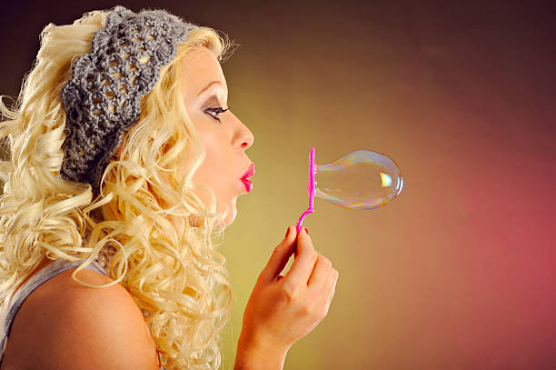 istock Attractive Blond With Curly Hair Blowing A Bubble 183792987