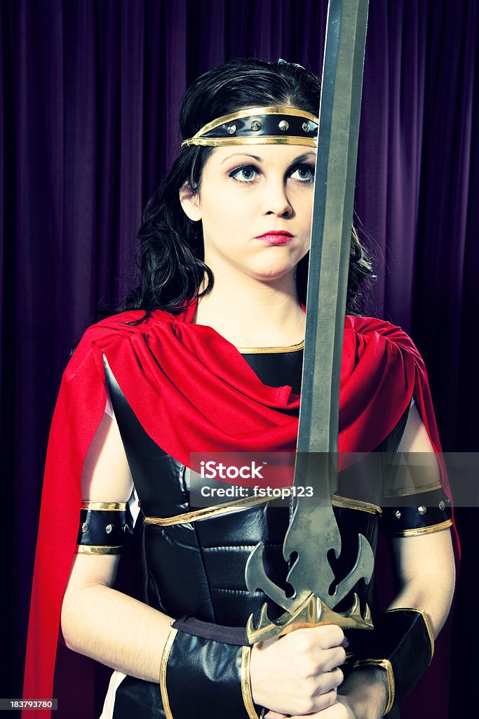 Belle jeune femme en costume de gladiateur tenant épée sur scène. - Photo de Guerrier libre de droits