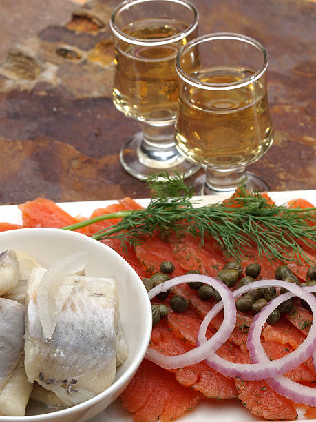 Gravlax (gravad lax, gravet laks, gravlaks) "Scandinavian Salt and Sugar cured salmon platter with fresh dill, red onion and capersPickled Herring and shot glasses" gravad stock pictures, royalty-free photos & images