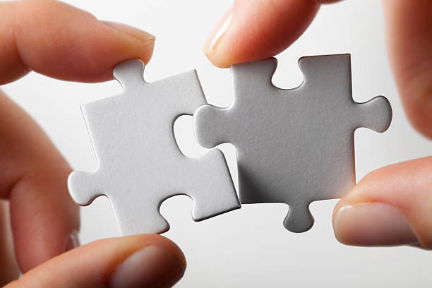 Connection. Hands trying to fit two puzzle pieces together. Hands trying to fit two puzzle pieces together. closing photos stock pictures, royalty-free photos & images