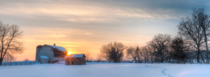 Minnesota scenic winter farm sunset. Panoramic winter shot of a Minnesota farm during sunset. Notice the trail in the snow leads back to the horse by the barn.