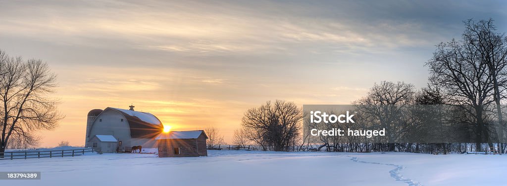 Panoramic winter landscape Minnesota scenic winter farm sunset. Panoramic winter shot of a Minnesota farm during sunset. Notice the trail in the snow leads back to the horse by the barn. Winter Stock Photo