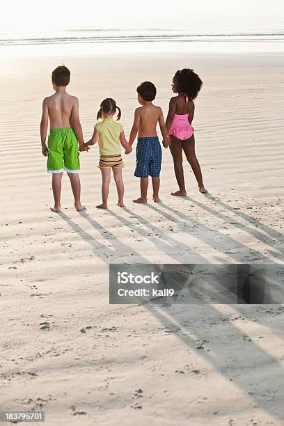 Cztery Wielorasowe Dzieci Trzymając Się Za Ręce Na Plaży - zdjęcia stockowe i więcej obrazów Dziecko