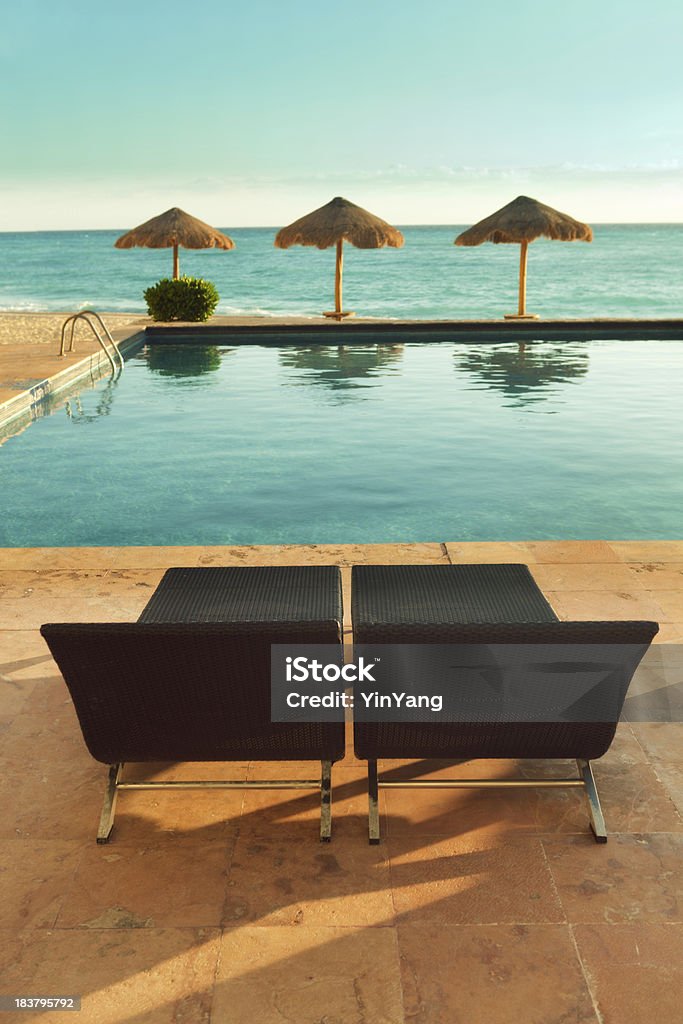 Cadeira do Deck par da piscina, Palapas e Mar do Caribe - Foto de stock de Cadeira royalty-free