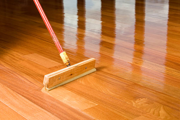 istock Squeegee Style Brush Applying Clear Polyurethane to Hardwood Floor 183796290