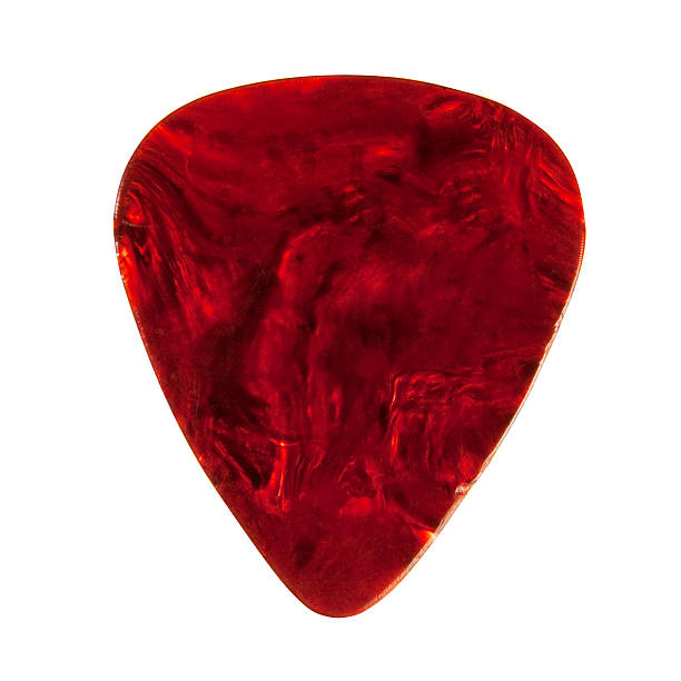 A plectrum guitar pick with a marbled red finish "Photo of a patterned, plastic guitar pick/plectrum showing signs of use" plectrum stock pictures, royalty-free photos & images