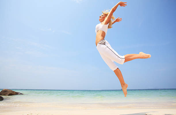 Happy girl jumping on the tropical beach.