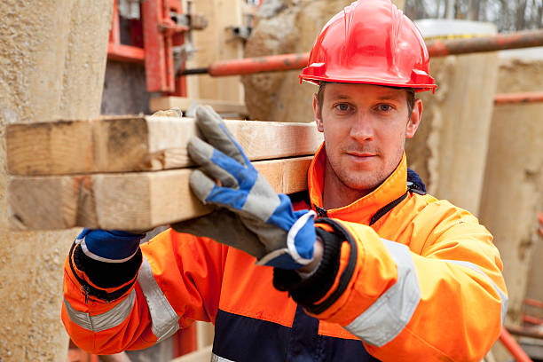 плотник, улыбается на строительной площадке. - construction safety mid adult men road construction стоковые фото и изображения