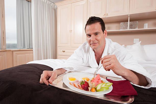 istock Man happily eating breakfast in bed 183797773