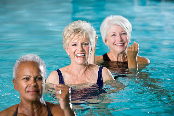 multiraciale femmes seniors dans l'eau cours d'aquagym - sc0450 photos et images de collection