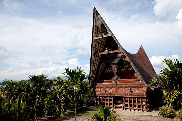 lake toba batak house "Batak architecture refers to the related architectural traditions and designs of the various Batak peoples of North Sumatra, Indonesia. Batak houses are boat-shaped with intricately carved gables and upsweeping roof ridges." danau toba lake stock pictures, royalty-free photos & images