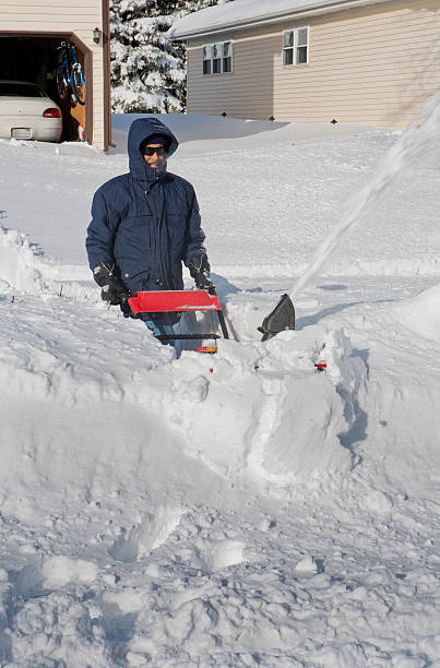 istock man pushing snowblower following blizzard 183799578