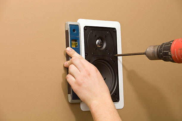 Worker Installing a Residential Wall Speaker  surround sound stock pictures, royalty-free photos & images