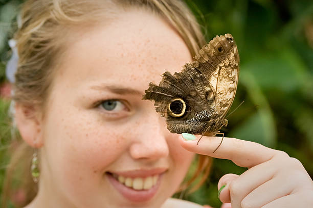 istock Girl with butterfly (Caligo memnon) on her finger 183800098