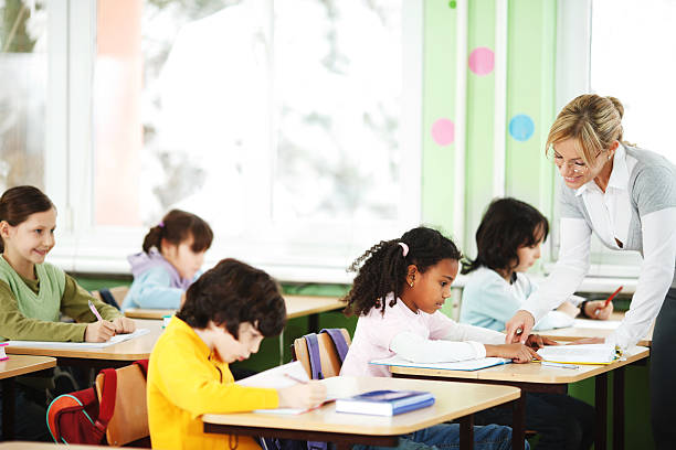 istock Primary school pupils and teacher working in classroom. 183800121