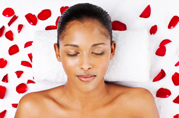 istock Young Woman Lying on a Bed with Rose Petals 183800401