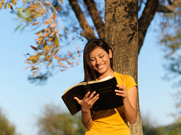 alegre mujer latina - christian mujer leyendo la biblia fotografías e imágenes de stock