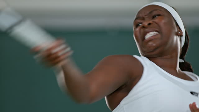 SLO MO Black female tennis player striking the incoming ball