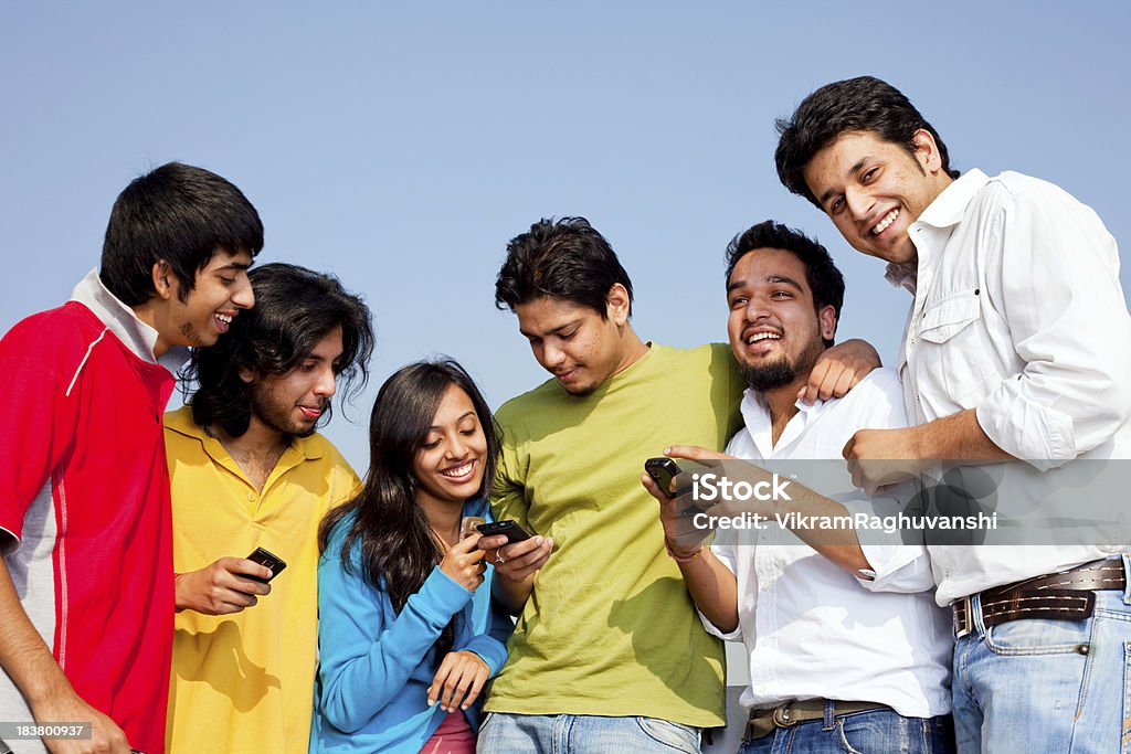 Seis jovens amigos indianos pessoas leitura SMS no celular - Foto de stock de 20 Anos royalty-free