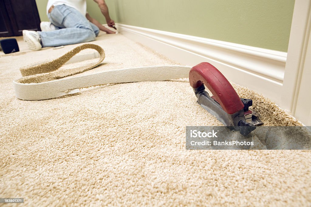 Alfombra con dormitorio y trabajador instalación de alicates de corte - Foto de stock de Instalar libre de derechos