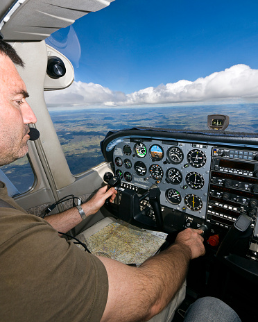 Pilot navigating and checking instruments