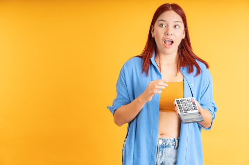 University student using the calculator, on an orange background